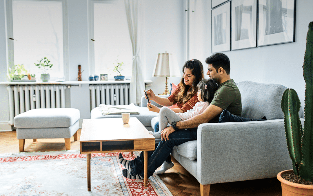 La famille est heureuse dans le salon, car les stores extérieurs la protègent de la chaleur.